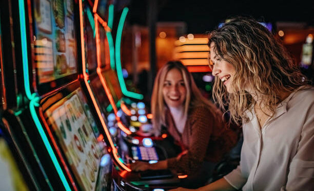 Girl friends gambling in casino on slot machinery