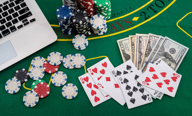 poker chips with banknotes placed on a laptop keyboard. Poker concept